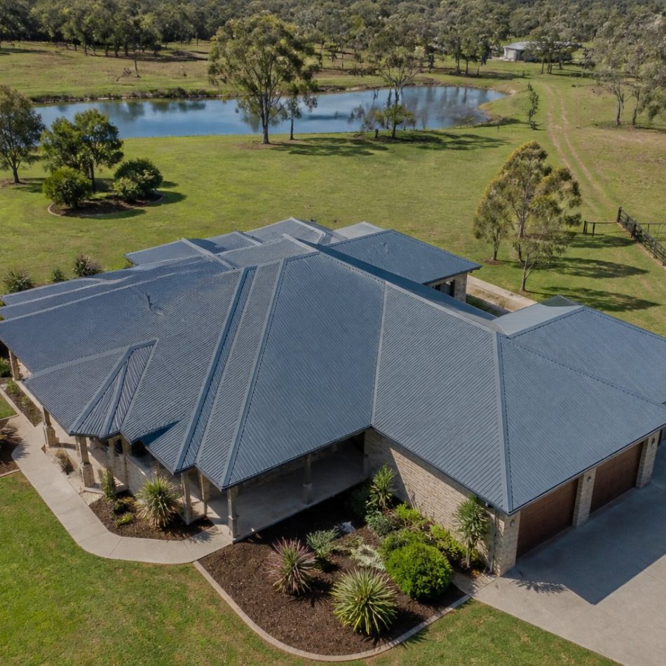 aerial view of an Australian acreage home with a grey corrugated Colorbond roof among gum trees